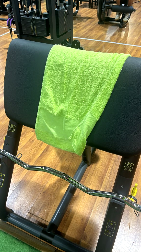 Panca Scott con bilanciere curvo e asciugamano verde