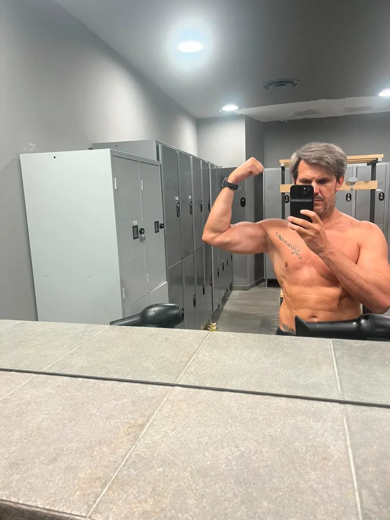 Gino Capon selfie specchio spogliatoio con bicipite flesso dopo allenamento spalle-dorsali