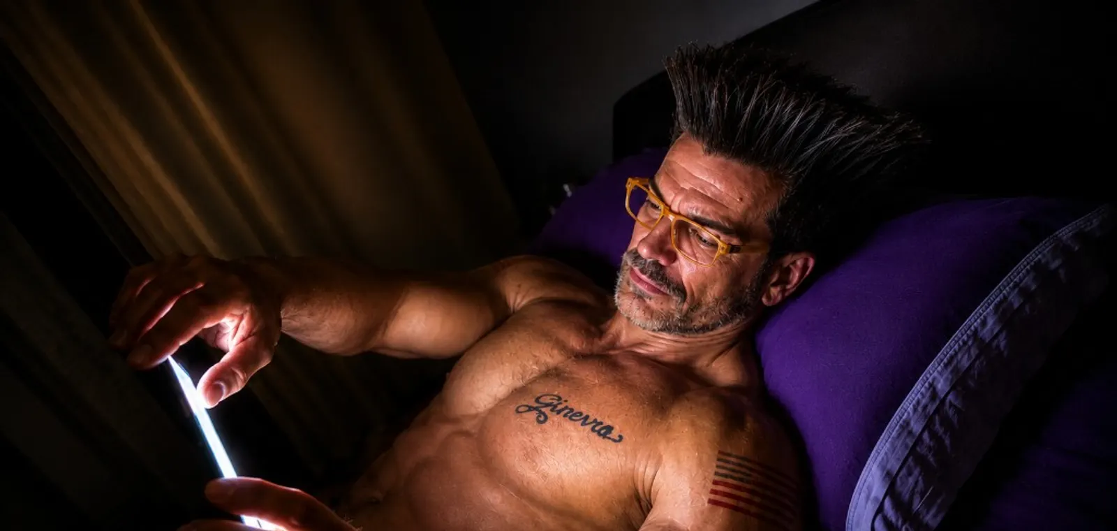 Scena serale: Gino a letto con tablet illuminato, lettura immersiva prima di dormire — immagine elaborata con IA